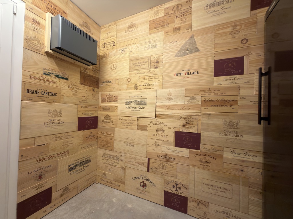 Mur habillé de caisses à vin en bois, rangées et organisées avec soin